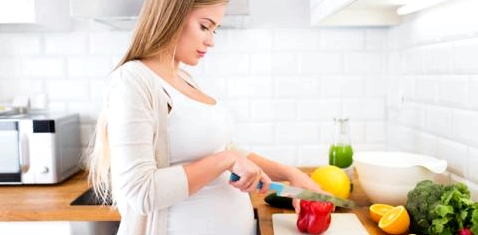 Eine schwangere Frau kocht