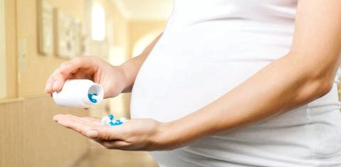 Eine schwangere Frau nimmt Tabletten