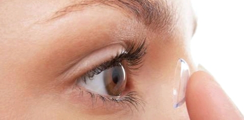 Frau setzt sich Kontaktlinse ein
