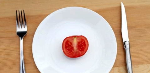 Auf einem Teller liegt eine halbe Tomate