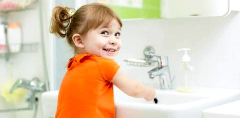 Ein kleines Mädchen wäscht sich die Hände