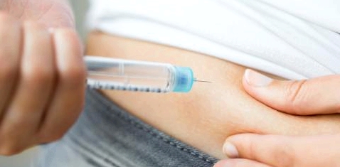 Eine Diabetikerin spritzt sich Insulin in den Bauch