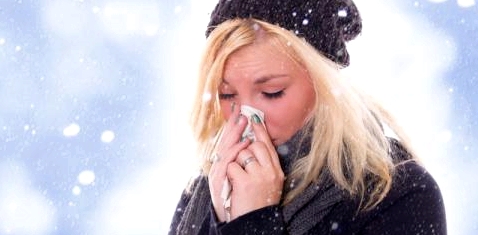 Eine Frau putzt sich im Schnee die Nase