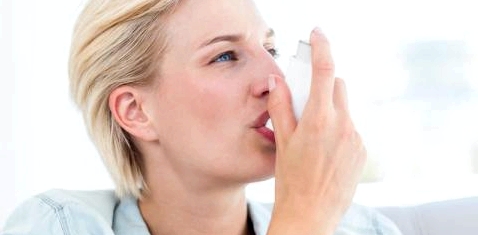 Eine Asthmatikerin inhaliert