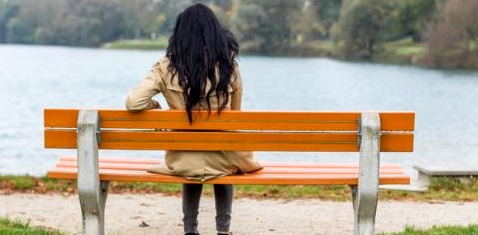 Eine einsame Frau auf der Parkbank
