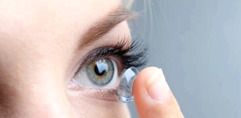 Eine Frau setzt sich eine Kontaktlinse ein