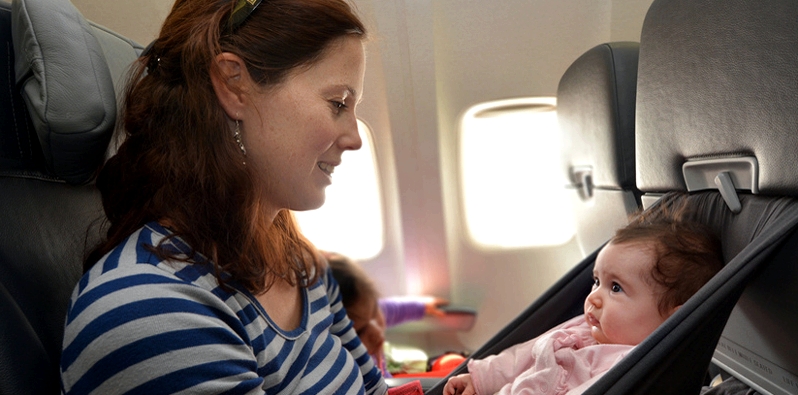 Frau mit Baby im Flugzeug