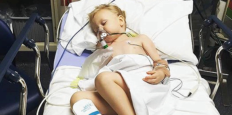 Ein Junge liegt in einem Krankenhausbett