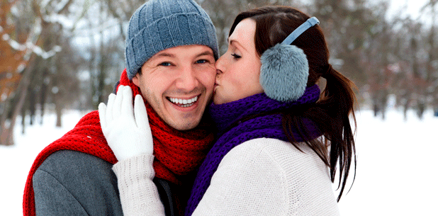 Eine Frau küsst einen Mann im Schnee